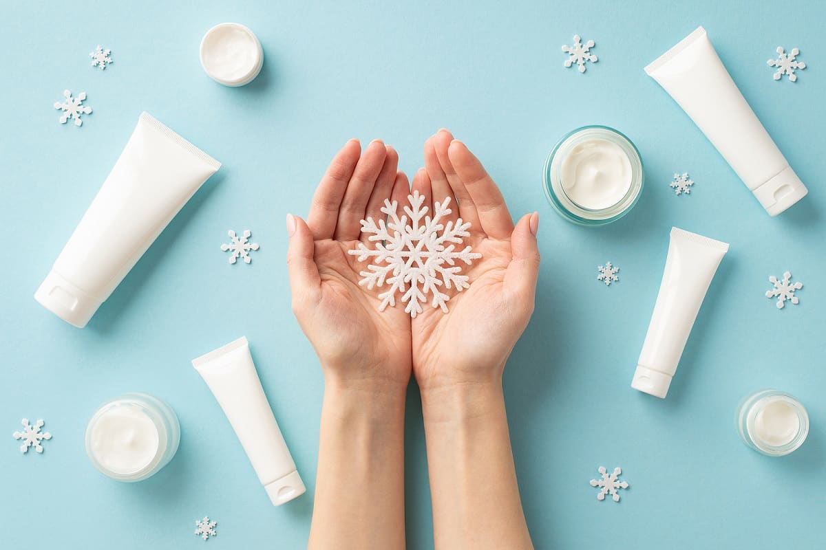 person holding a snowflake, and creams around the hands